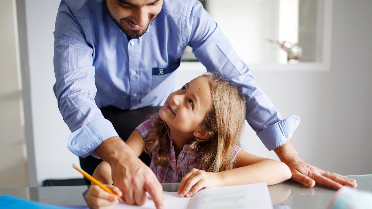 Father helps his daughter with homework