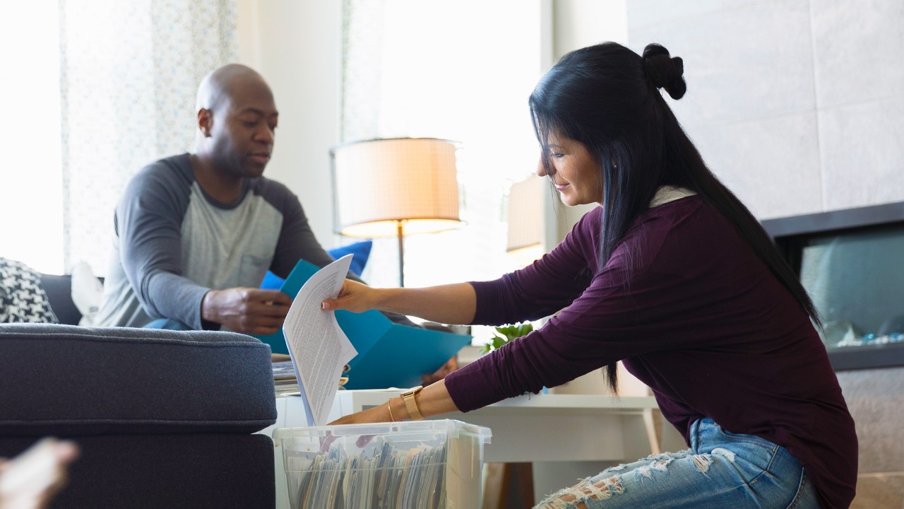 Couple filing paperwork at home